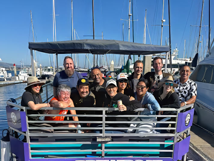 Group of friends raising drinks aboard the Bay Area Brew Boat in the Oakland Estuary